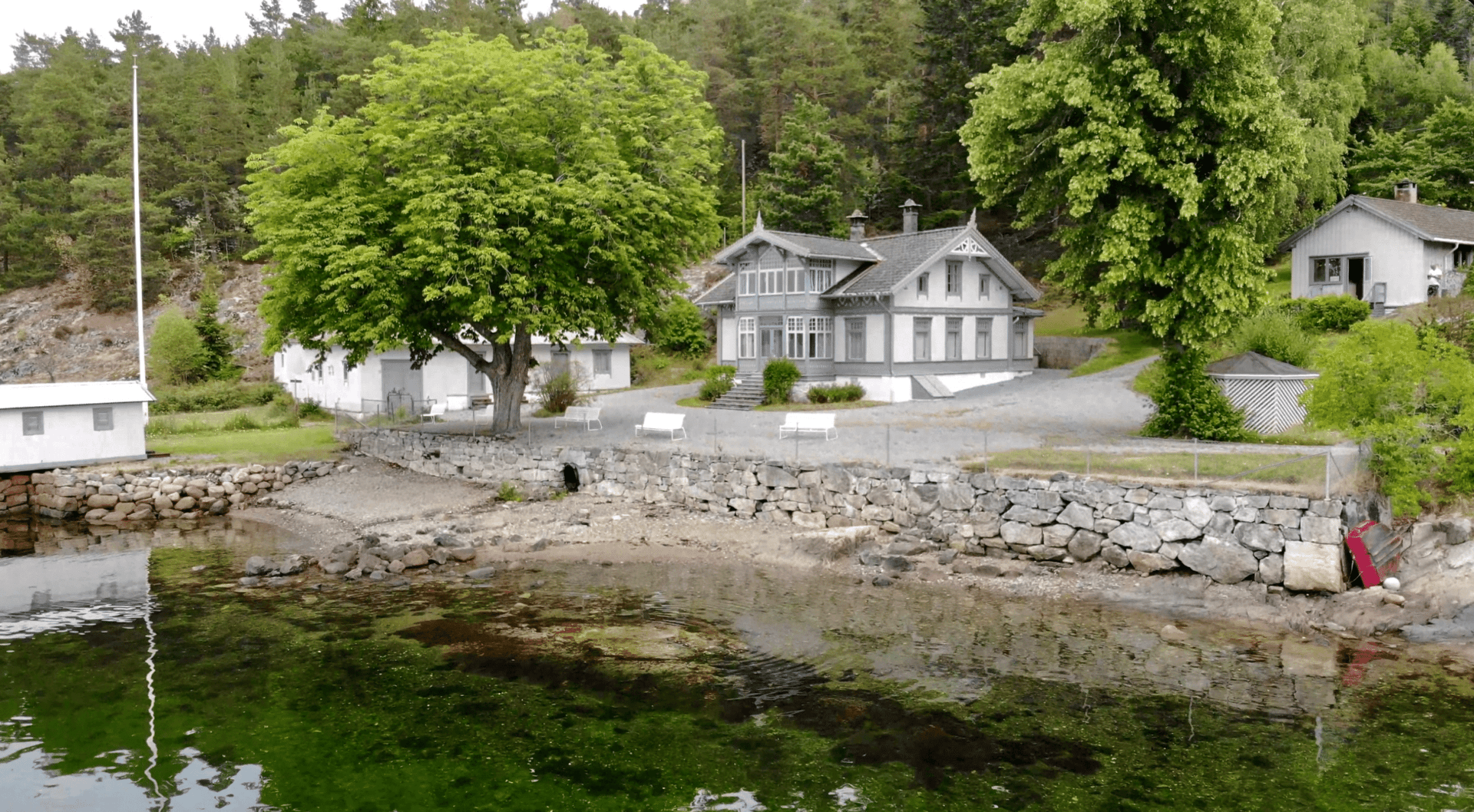 grått hus ved oslofjorden med strand