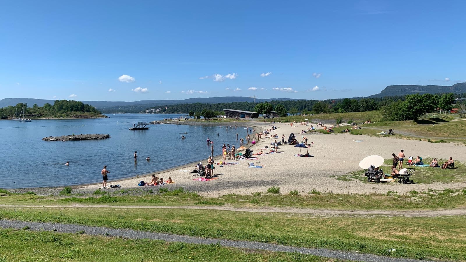 Mennesker på en strand folk som koser seg i sola