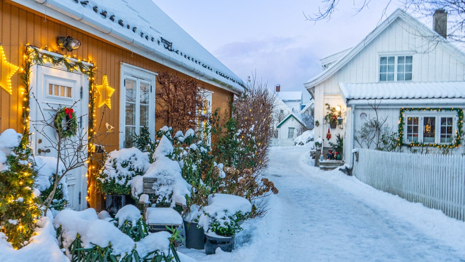 Gate med trehus og julebelysning vinter