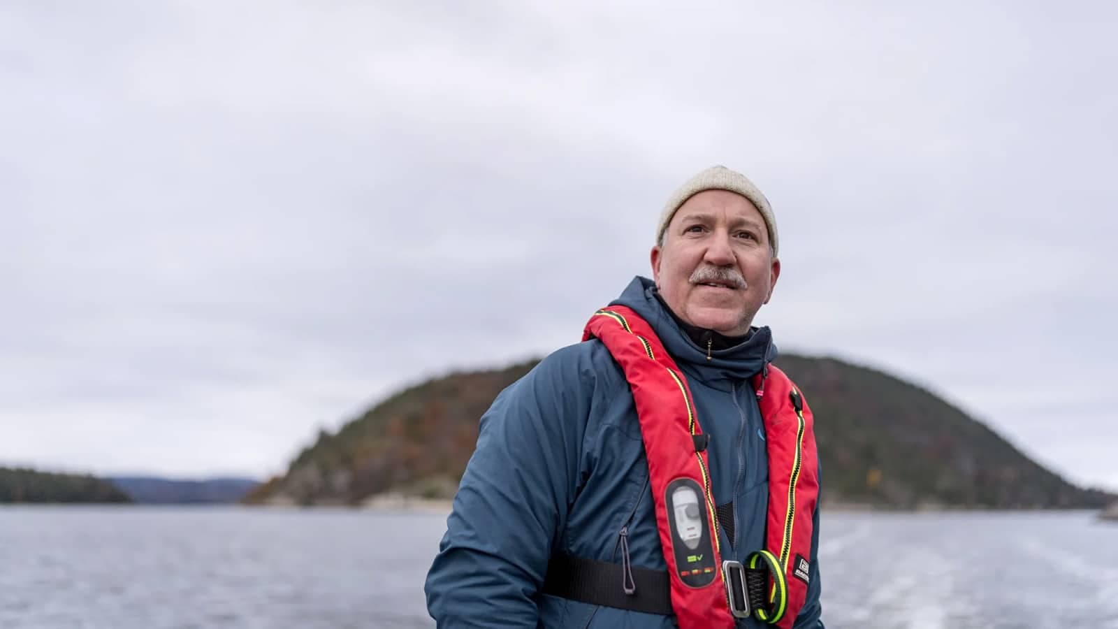 Bilde av en mann på fjorden med lue og redningsvest