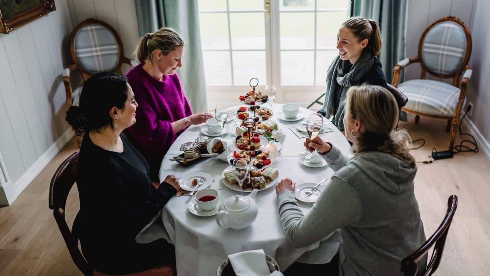 Fire venninner som har Afternoon tea rundt et bord